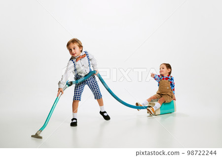 Happy brother. Little kids, boys cleaning house with vacuum cleaner and playing over grey background Happy brother. Little kids, boys cleaning house with vacuum cleaner and playing over grey background 98722244