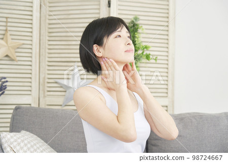 Woman doing neck lymphatic massage at home 98724667