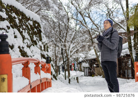 冬天下著大雪的一天，帶著相機來到京都大原的中年男子。 98725876