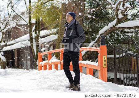 冬天下著大雪的一天，帶著相機來到京都大原的中年男子。 98725879