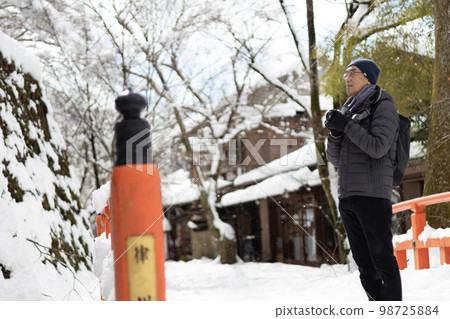 A middle-aged man who came to Ohara, Kyoto with his camera on a day of heavy snowfall in winter. 98725884
