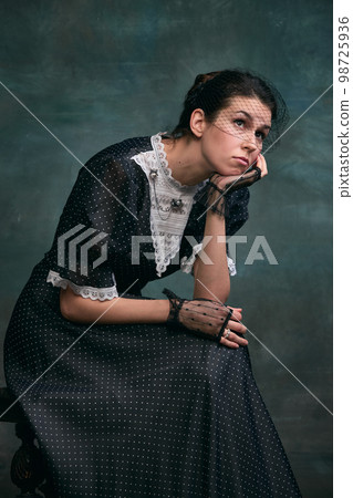 Thoughtful, dreamy look. Beautiful woman in image of Anna Karenina in retro black dress over vintage dark green background. Concept of literature character, history Thoughtful, dreamy look. Beautiful woman in image of Anna Karenina in retro black dress over vintage dark green background. Concept of literature character, history 98725936