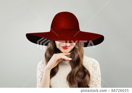 Beautiful woman in red wide broad brim hat. Pretty model with red lips makeup  98726035