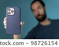 the video editor program on the phone. A young man is editing a video on his phone 98726154