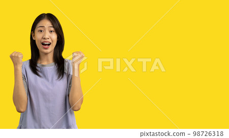 Asian woman posing extremely happy to win, Successful, Show extreme happiness, Very happy, yes, Lonely woman on yellow background. Asian woman posing extremely happy to win, Successful, Show extreme happiness, Very happy, yes, Lonely woman on yellow background. 98726318