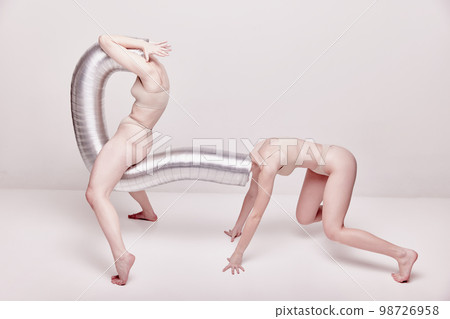Blind following. Creative photography with two young girls posing in nude underwear over beige studio background. Concept of cringe, queer, weird people 98726958