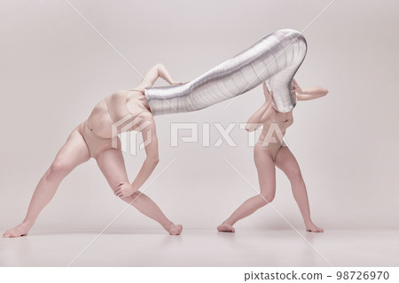 Illusion. Creative photography with two young girls posing in nude underwear over beige studio background. Concept of cringe, queer, weird people 98726970