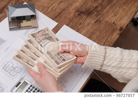 [一位家庭主婦正在為買房做計算] 98727857