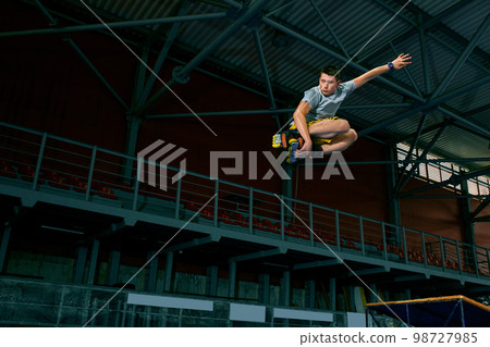 The man performs a trick. Jump. Indoor training The man performs a trick. Jump. Indoor training 98727985