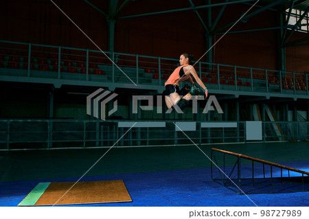The young woman performs a trick. Jump. Indoor training The young woman performs a trick. Jump. Indoor training 98727989