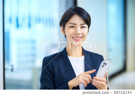 穿著西裝的中層女商人在辦公室操作智能手機 98728143