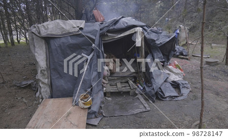 Homemade homeless dwelling next to a landfill. 98728147