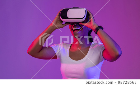 Portrait Of Excited Black Woman Wearing VR Headset In Neon Light 98728565