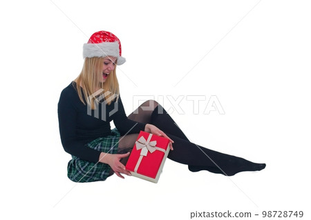 woman sitting with christmas hat and present in isolated background 98728749