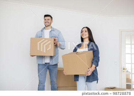 Relocation Concept. Happy Young Spouses Walking With Cardboard Boxes In Hands 98728878