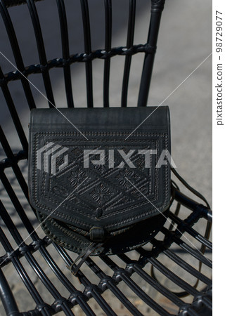 small black women's leather bag with a carved pattern. selective focus 98729077
