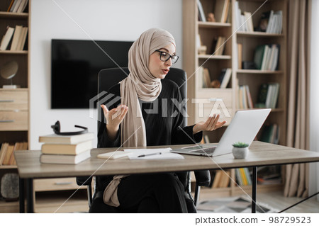 Working process at office of young girl in headscarf. Working process at office of young girl in headscarf. 98729523