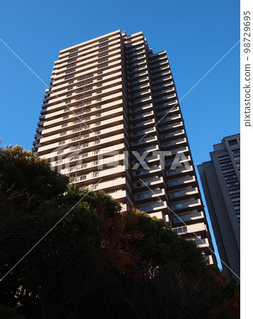 Apartment buildings towering under clear skies 98729695