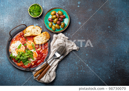 Middle Eastern and Maghrebi healthy dish Shakshouka made of eggs and tomato sauce served in pan Middle Eastern and Maghrebi healthy dish Shakshouka made of eggs and tomato sauce served in pan 98730070
