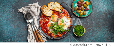 Middle Eastern and Maghrebi healthy dish Shakshouka made of eggs and tomato sauce served in pan Middle Eastern and Maghrebi healthy dish Shakshouka made of eggs and tomato sauce served in pan 98730100