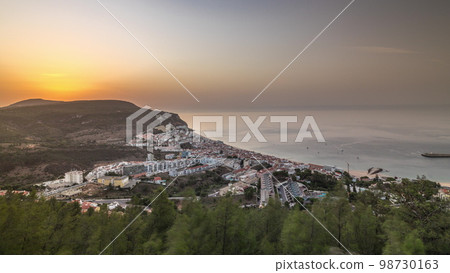 Aerial sunrise view of the coastline of the village of Sesimbra timelapse. Portugal Aerial sunrise view of the coastline of the village of Sesimbra timelapse. Portugal 98730163