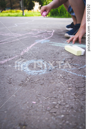 Children draw with chalk on the road. Children's creativity on the street. Children draw with chalk on the road. Children's creativity on the street. 98730192