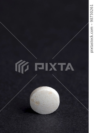 White and yellow medical medicines on a black background White and yellow medical medicines on a black background 98730261