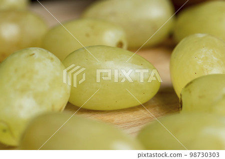 Harvested green grapes on the table Harvested green grapes on the table 98730303