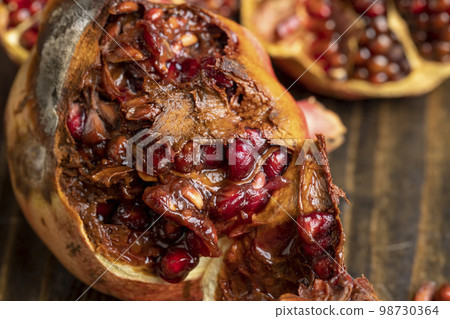 Rotten spoiled red ripe pomegranate on the board 98730364