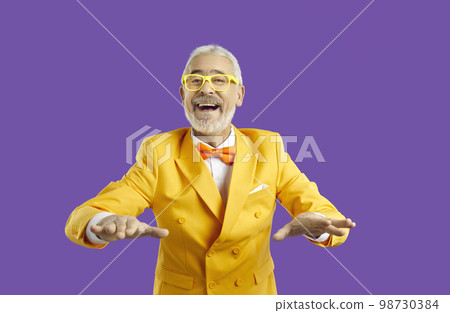 Funny senior man in suit on violet studio background Funny senior man in suit on violet studio background 98730384