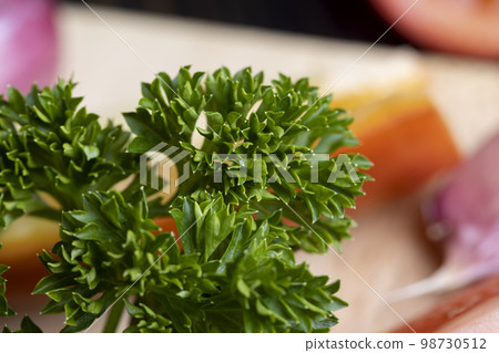 Clean washed parsley on the table during cooking Clean washed parsley on the table during cooking 98730512