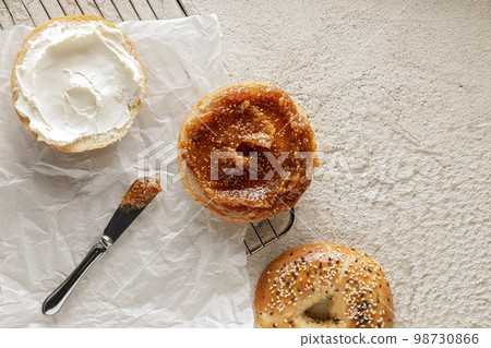 Freshly baked bagel with cream cheese and fig jam on baking paper 98730866