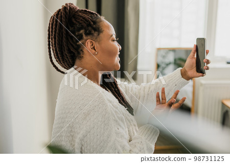 Portrait African american woman making video call in bedroom - social networks and connection 98731125