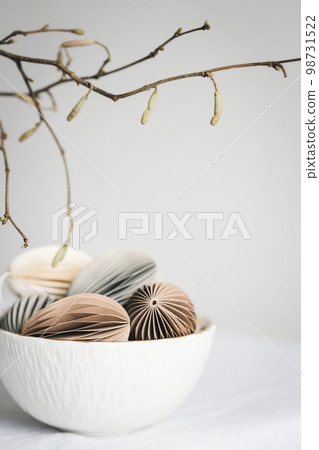 Easter egg-shaped pastel colored decorations, made out of cardboard in white bowl. Easter egg-shaped pastel colored decorations, made out of cardboard in white bowl. 98731522