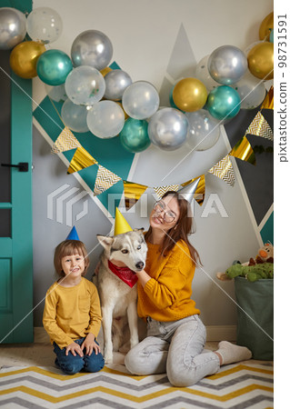 Dog pet birthday, family mother and child hug their dog congratulating happy birthday 98731591