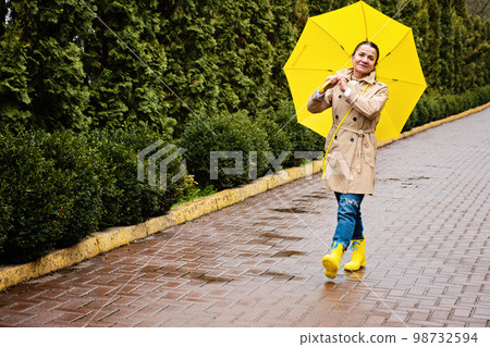 Happy senior woman in yellow rain coat with yellow umbrella Encouraging self-care and relaxation, Using the rain as opportunity for reflection and introspection Happy senior woman in yellow rain coat with yellow umbrella Encouraging self-care and relaxation, Using the rain as opportunity for reflection and introspection 98732594