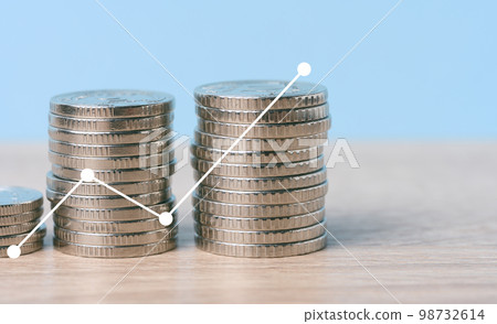 A stack of metallic coins and a chart with growing rates. High income in business, price increase, profit analysis A stack of metallic coins and a chart with growing rates. High income in business, price increase, profit analysis 98732614