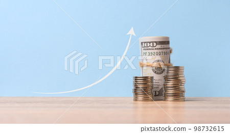 Stack of metallic coins and a graph on a blue background. Income growth in business, high profitability Stack of metallic coins and a graph on a blue background. Income growth in business, high profitability 98732615