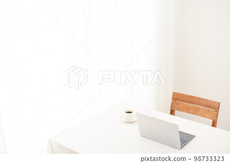 白色桌子上的一台筆記本電腦和一杯咖啡(專注於筆記本電腦的背面) 白色桌子上的一台筆記本電腦和一杯咖啡(專注於筆記本電腦的背面) 98733323
