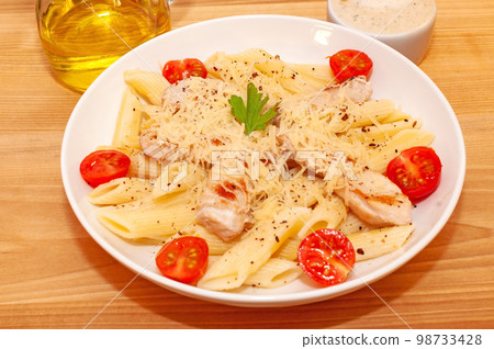 Pasta with chicken and tomatoes 98733428