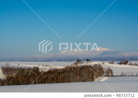 Hilly area and snowy mountains on a sunny winter day Daisetsuzan 98733712