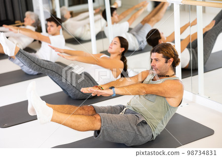 Group of different people doing exercises in gym Group of different people doing exercises in gym 98734831