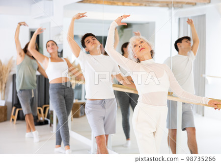Elderly woman doing choreography at ballet barre Elderly woman doing choreography at ballet barre 98735266
