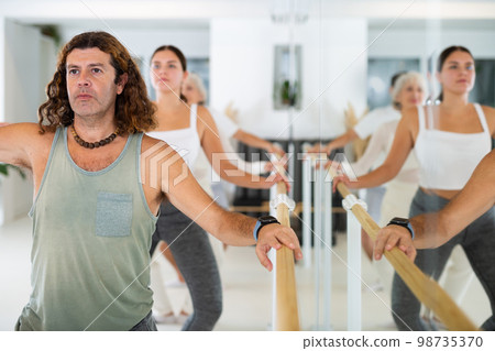 Adult man doing ballet at barre Adult man doing ballet at barre 98735370
