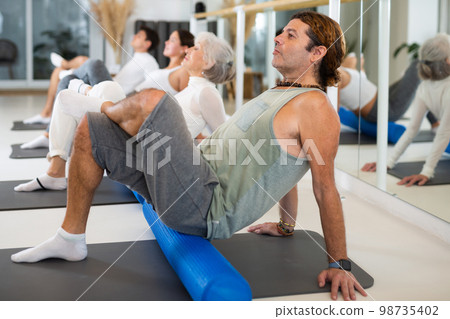 Adult man doing pilates with roller 98735402
