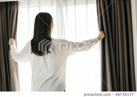 女人拉開窗簾，醒來的形象 98736157