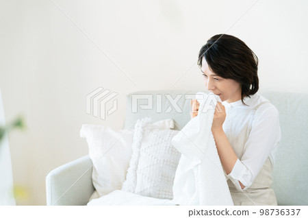 一位女士確認洗過的毛巾的氣味 98736337