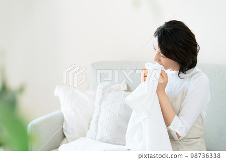 一位女士確認洗過的毛巾的氣味 98736338