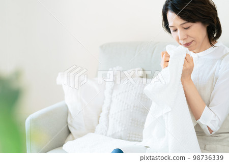 一位女士確認洗過的毛巾的氣味 98736339