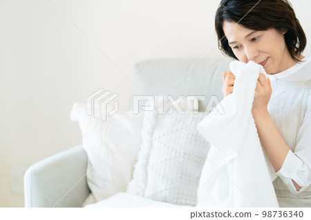 一位女士確認洗過的毛巾的氣味 98736340